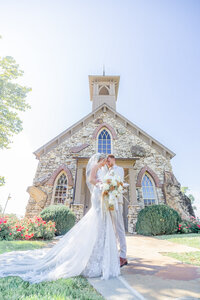 bride and groom in front of top of the rock chapel in Branson MO