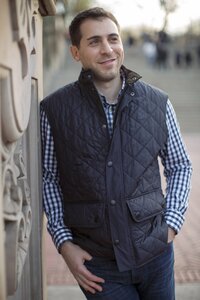 Central park engagement photos, Deborah Zoe Photography. A man in a blue vest looks off in Central Park.