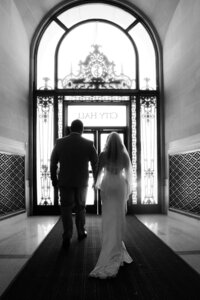 bride and groom exit under sign san francisco city hall wedding