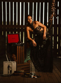 Senior portrait at Triple T Farms in Fruitdale, Alabama — leaning on her knee on wooden crates
beside an open vintage record player.