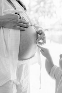 Toddler and mom booping pregnant belly