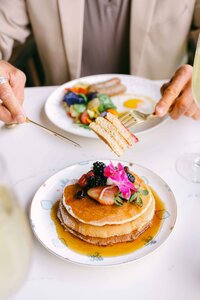 Guest served pancakes and eggs at a garden brunch table