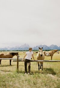 Sam Dykstra, gay photographer, modeling with horses in Wyoming at the grand tetons.