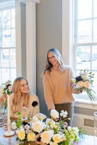 Two women smiling and making bouquets at Maison Charlottesville - photo by Jo Mahoney