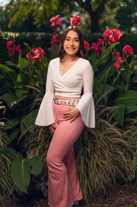 A girl from Germantown High School stands in front of a large blooming plant in Eagle. WI's Paradise Springs during her senior photo session.