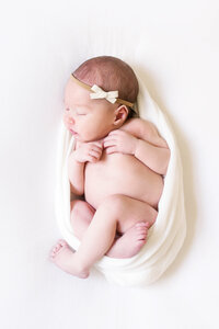 Newborn baby in wrap on beanbag