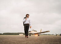 Senior portrait at a small hangar near Mobile International Airport in Mobile, Alabama — walking
Senior portrait at a small hangar near Mobile International Airport in Mobile, Alabama — suit
jacket over his shoulder, wearing aviators with the plane in the background.