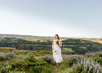 Sandy, Oregon high school senior walking through a field of wildflowers and Tom McCall nature preserve near Rowena in the Columbia River Gorge.