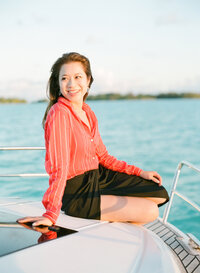 Happy bride on honeymoon on her private boat and nice red outfit