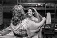 Jacksonville, FL portrait session capturing A bride beams with excitement while her mother-in-law carefully adjusts her veil during a quiet pre-ceremony wedding moment.