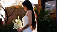 Bride looking at her bouquet with the Paseo in the background.
