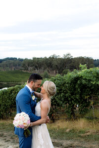 Couple embracing in vineyard overlooking rolling hills