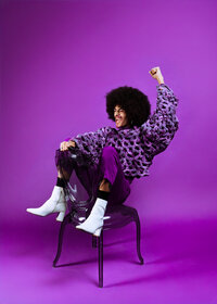 Musician photographed in a monochromatic purple studio portrait