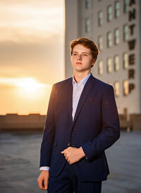 Senior portrait in downtown Mobile, Alabama— waist up in his dress suit looking slight off camera.
