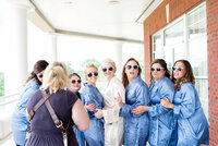 behind the scenes of Mahlia chatting with bride and her bridesmaids on the balcony at Stones River Country Club