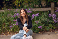An Arrowhead senior sits in front a split rail fence and purple flowers at Retzer Nature Center.