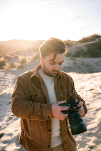 Zakelijke foto van man met camera op strand egmond