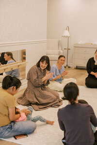 Women clapping while singing with toddlers