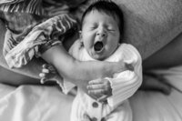 black and white image of newborn yawning