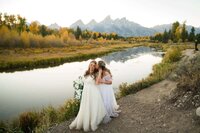 Bride and bride share a kiss in front of the grand tetons at swabacher's landing