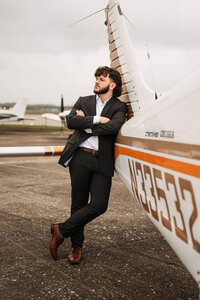 Senior portrait at a small hangar near Mobile International Airport in Mobile, Alabama — posing near airplane