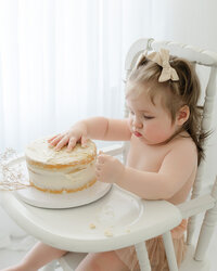 Baby with cake during milestone session with Niceville family photographer
