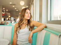 Senior portrait at Sunliner Diner in Gulf Shores, Alabama — sitting in a booth and looking out
the window.