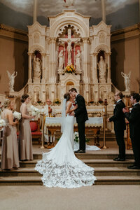 Bride and groom share their first kiss at the altar during a traditional church wedding ceremony.