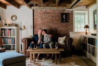 Husbands gaze into each others eyes while sitting on a sofa