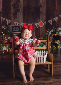 Little girl holding strawberries during cake smash photoshoot in Franklin Tennessee photography studio
