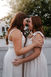 lesbian couple kissing and wearing white dresses