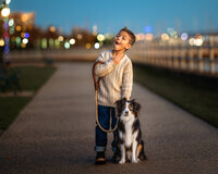 Young boy standing with his dog on a walkway during a golden hour session in New Bern North Carolina