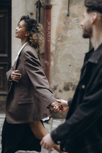 Couple walking hand in hand in the streets of Prague