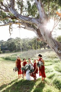 Bridal party walking beneath large tree during outdoor wedding