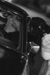wedding couple kissing in classic car at night at the exchange 1874 in woodbridge california