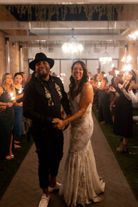 Bride in a lace mermaid-style gown walking together with the groom during their intimate wedding