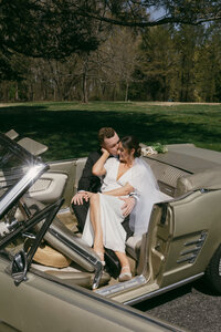 bride and groom embracing in vintage green mustang