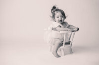 Charleston Cake Smash Photographer- Baby looks into the camera during Milestone Portraits at Holy City Babies Portrait Studio in Charleston, SC.