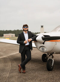 Senior portrait at a small hangar near Mobile International Airport in Mobile, Alabama — posing near airplane
