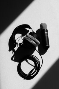 Voice over artist photographed with professional audio gear in a black and white personal brand portrait.