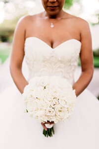 bride holding a bouquet of white roses