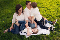 A Delafield, WI family sit playfully on a blanket in a Waukesha orchard.