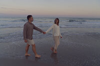 couple chasing each other down the beach, wilmington beach, north carolina