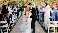Bride and groom kissing at the end of the aisle after their ceremony
