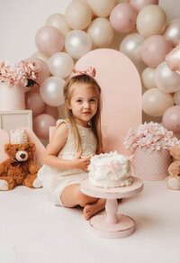 Charleston Cake Smash Photographer- Baby looks into the camera during Cake Smash Photos at Holy City Babies Portrait Studio in Charleston, SC.