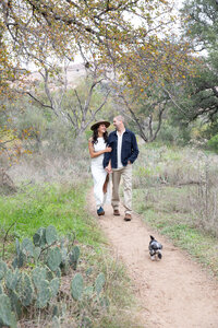 Austin wedding photographer capturing a couple walking down a picturesque trail with cactus trees in the background.