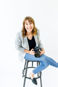 Photography business coaching client, Amanda McPhee, holding her camera.