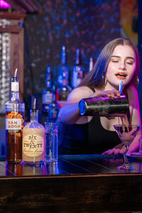 a bartender pouring a drink at a bar