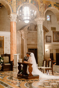 Catholic bride and groom cut their wedding cake at the reception