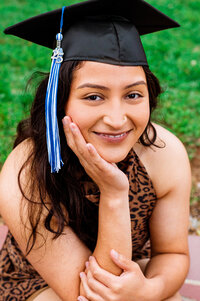 Senior grad smiling at the camera wearing cute leopard print dress on MTSU campus